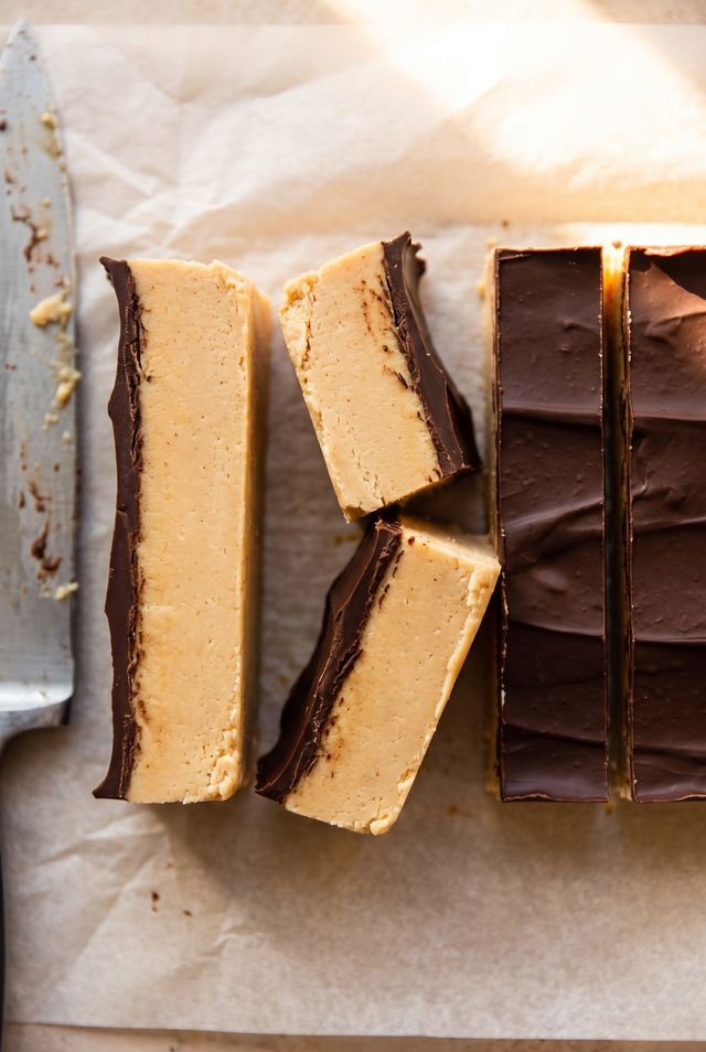 Peanut butter protein bars standing on their cut edges, showing a smooth peanut butter fudge center under a cracked dark chocolate shell